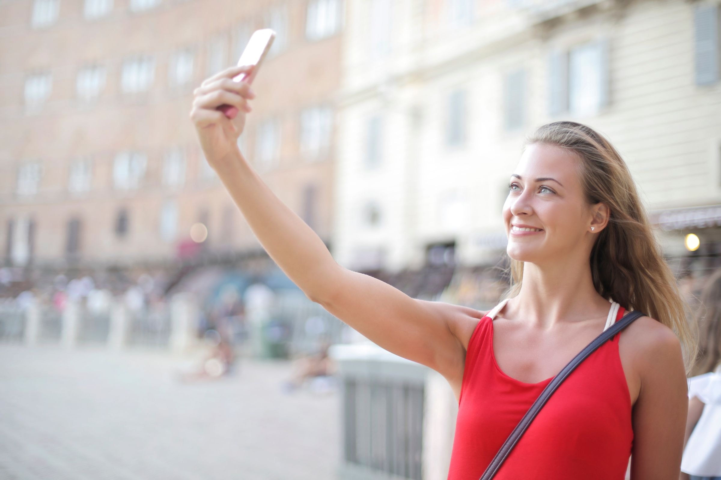 Woman using her phone to take a selfie for a passport photo